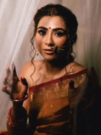A portrait of the model looking through a sheer curtain, her face partially veiled. This artistic composition plays with layers and light to create a beautiful and intriguing frame.