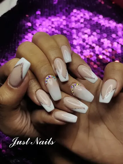 A modern twist on the classic French manicure. This set features a soft pink to white ombre base on coffin-shaped nails, enhanced with delicate silver glitter lines and strategically placed rhinestones at the cuticle for a touch of sparkle.