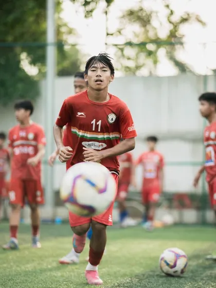 A player focuses on his dribbling, a fundamental skill honed during our camps. Close ball control is essential for any aspiring professional footballer.