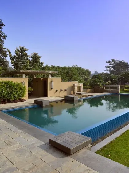 The pool area at C Farm is designed with clean lines and natural materials. Stone decking and integrated planters create a seamless transition from the water to the lawn, while a feature wall adds architectural interest and privacy.
