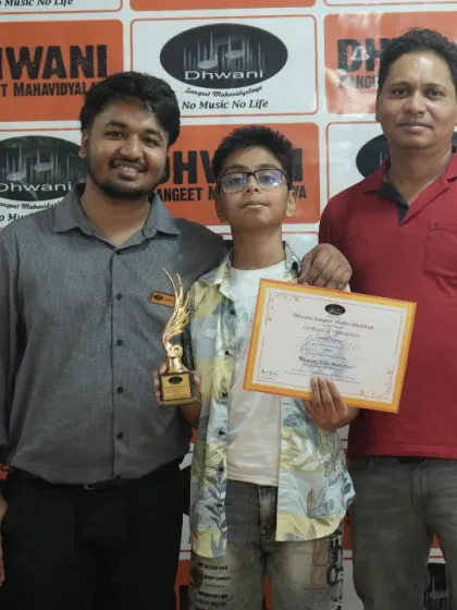 A student stands proudly with his teachers and his award. Our gurus take immense pride in the accomplishments of their students.