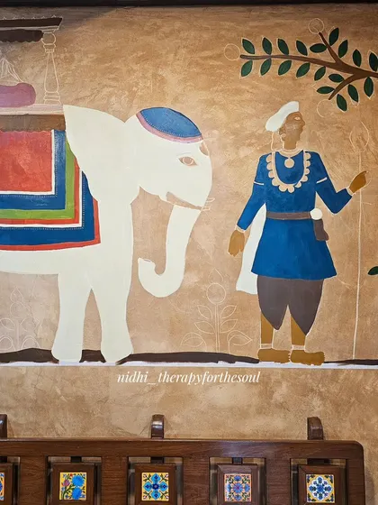 The elephant and guard figures are taking shape. This stage involves layering colors to build richness and depth before the final outlining and detailing begins.