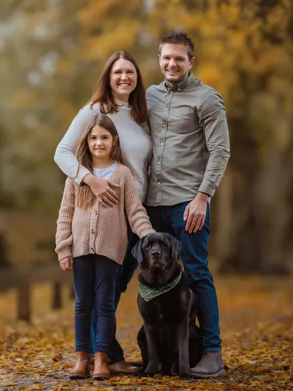A classic family portrait that radiates warmth and togetherness. The coordinated outfits and the beautiful autumn backdrop make this a timeless keepsake.