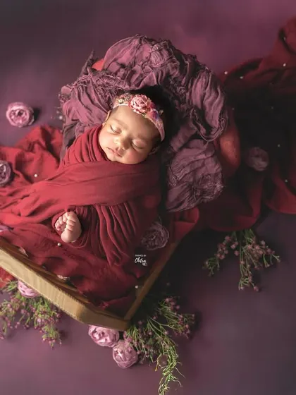A portrait of peaceful slumber, wrapped in rich plum and deep red tones. My styled studio sessions use beautiful colour palettes and soft textures to create artistic, memorable images of your baby.