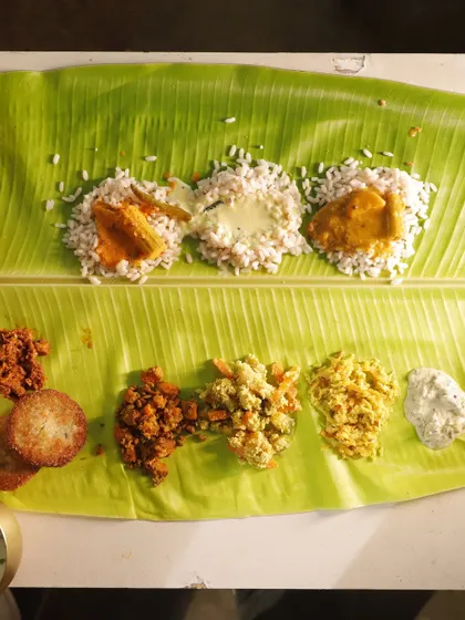 A closer look at the heart of the Sadya. You can see the mounds of rice ready to be mixed with flavorful curries, alongside portions of thoran, avial, and crispy cutlets. Each component is placed thoughtfully on the banana leaf.