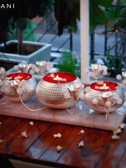 Where luxury meets functionality. This stunning centerpiece features three silver-plated bowls on a marble tray, surrounded by rose quartz-accented candle holders, creating a magnificent display of light and elegance.