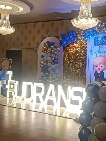 Another angle of Rudransh's Boss Baby party, showing the full stage with the balloon arrangements and glowing marquee letters.