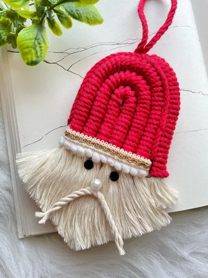 A cute little Santa Claus ornament, perfect for hanging on your Christmas tree or as a festive charm. The fluffy beard and red hat are just adorable.