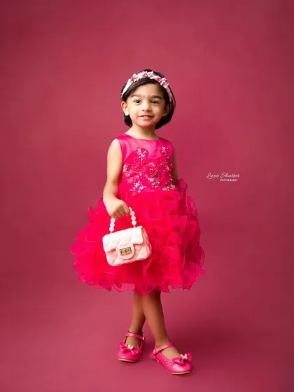A full-length shot of the birthday girl in her beautiful pink dress, showing off her confident and happy personality.