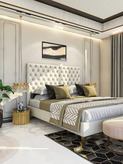 An elegant bedroom design featuring classic wall mouldings and a tufted, button-back headboard. The color palette is a sophisticated mix of cream, gold, and charcoal, creating a serene and luxurious atmosphere.