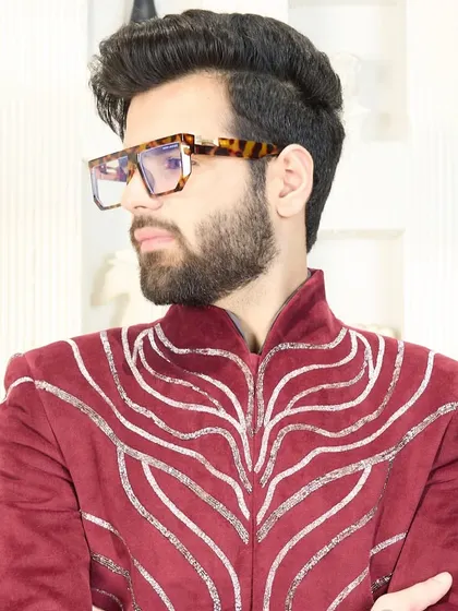 A close-up of the crimson velvet suit with intricate silver designs. This is festive elegance for the man who owns every occasion.