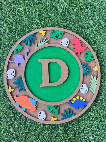Roar! Go back in time with this dinosaur themed monogram kit. Featuring the letter 'D', it's surrounded by colourful dinosaurs, eggs, and tropical leaves for a prehistoric adventure.