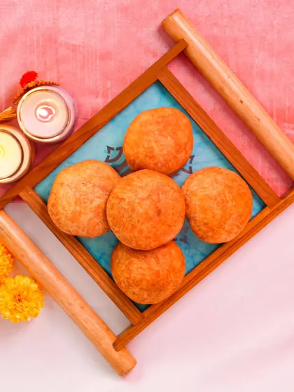 My customizable Diwali hampers are the perfect way to share joy. This one features mini kachoris beautifully presented in a festive tray with candles.