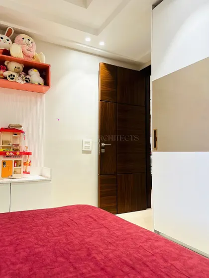 This view shows the functional side of the kid's room, with a sleek white wardrobe and open shelving for displaying toys and treasures.