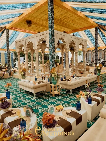 A wide shot of the lounge area, showing the comfortable and stylish seating arranged for guests to relax and enjoy the festivities. The colorful cushions add a pop of vibrancy.