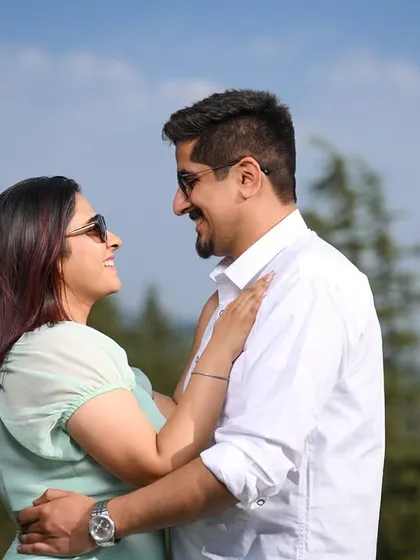 A classic candid shot of the couple looking at each other and smiling, capturing their easy and natural chemistry.