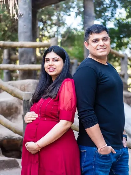 A simple and sweet back-to-back pose on a bridge. This casual portrait is perfect for capturing a relaxed and happy moment during a maternity session.