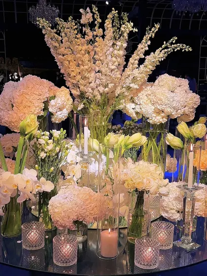 A close-up of a central floral arrangement, featuring a lush composition of white delphiniums, hydrangeas, and orchids. This display demonstrates our commitment to using premium blooms to create texture and volume in our luxury event designs.