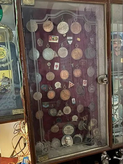 A display case filled with medals earned over the years. Each one tells a story of a fight, a victory, and the hard work it took to get there.