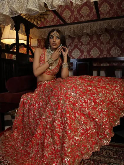 Seated gracefully, the bride looks radiant. This pose allows a closer look at the detailed work on the lehenga skirt and the stunning jewellery.