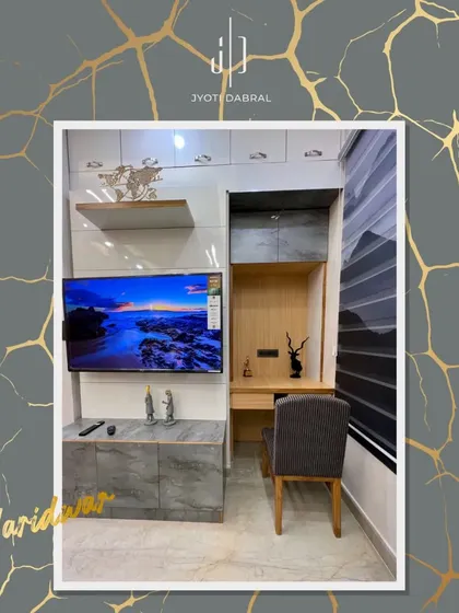 A compact and multifunctional unit in a Haridwar bedroom, combining a study desk, TV unit, and overhead storage. This is a great example of smart design for smaller spaces.