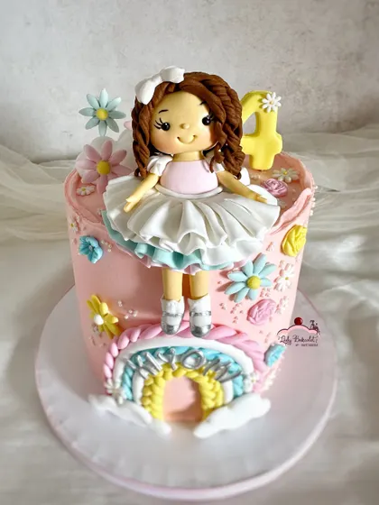 Somewhere over the rainbow! A sweet cake with a custom doll topper, a pastel rainbow, and delicate flowers.