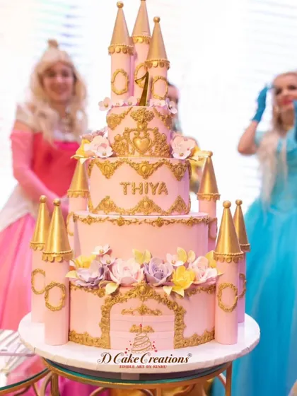 Another grand castle cake for a first birthday. This pink and gold masterpiece features multiple tiers, detailed castle towers, and beautiful floral accents, fit for a little princess.