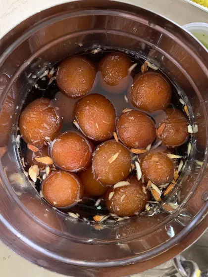 A bowl of soft, melt-in-your-mouth Gulab Jamuns, soaked in a fragrant sugar syrup. A perfect end to any meal.