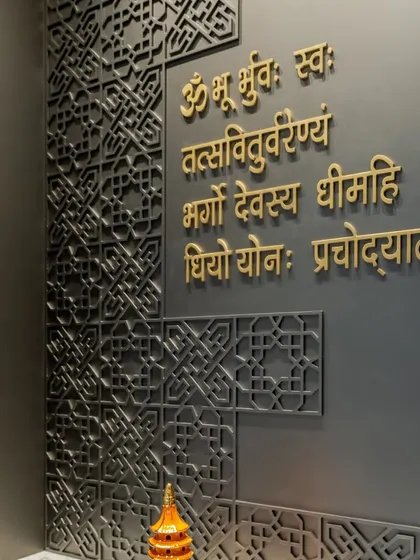 A detailed shot of the geometric CNC-cut paneling and the beautiful Sanskrit calligraphy. This highlights our focus on using intricate details and high-quality materials to create a space of spiritual significance.