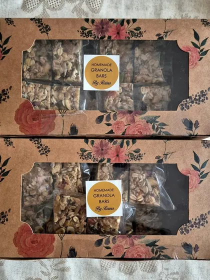 Two gift boxes of my homemade Granola Bars. These energy bars are packed with rolled oats, nuts, seeds, and dried fruits, making them a perfect healthy snack.