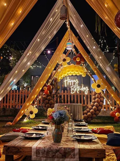 I create cozy and intimate celebrations too. This beautiful outdoor birthday setup features a low seating arrangement with comfortable cushions under a canopy of sheer yellow and white drapes, all lit up with magical fairy lights for a perfect evening party.