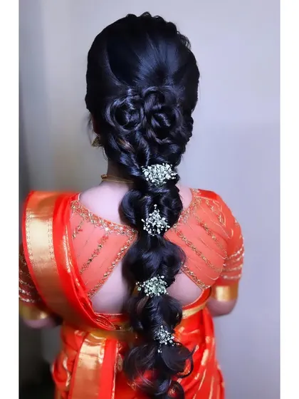 The final look for this client, with the modern bubble braid adorned with floral clips, perfectly complementing her orange saree which I also draped.