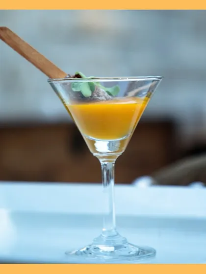 An elegant presentation of our Thai fritters with mango coulis, served in a martini glass for a touch of sophistication.