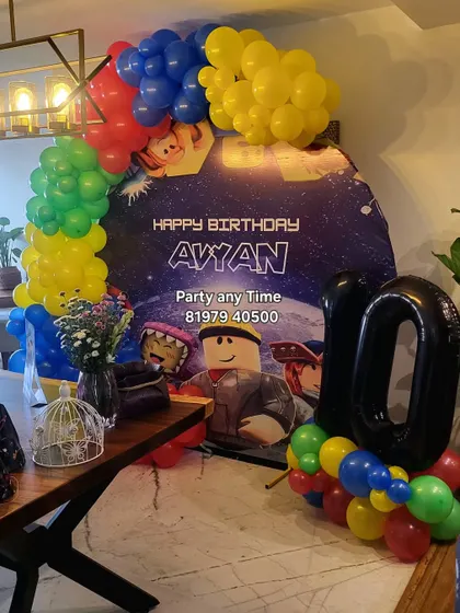 A Roblox theme party for a 10th birthday, with a custom character backdrop and a colorful balloon arch.