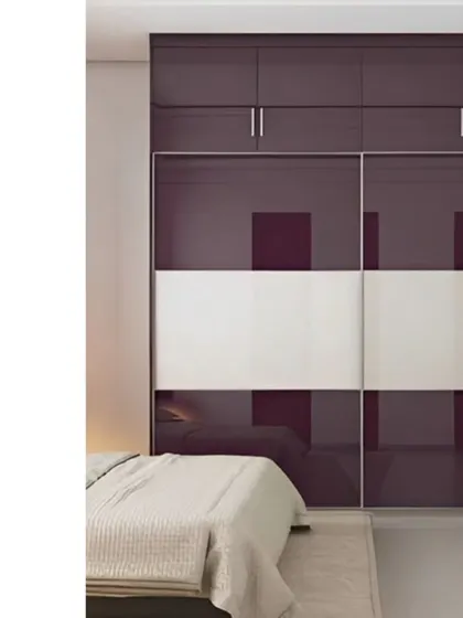 This sliding wardrobe combines deep purple and white glass panels for a chic and contemporary look. The loft storage above provides extra space, making it a practical choice for any bedroom.