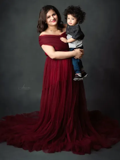 A mother holds her son, both looking stunning in our client closet gown and a coordinated outfit.