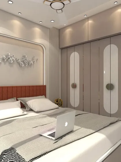 A bedroom in Bhayandar West with a warm, earthy color palette. The design includes a backlit headboard niche, custom wardrobes with rounded paneling, and a plush upholstered bed.