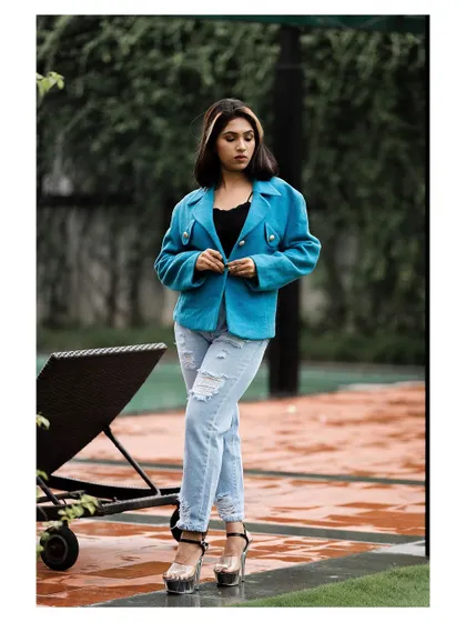 An outdoor fashion shot with a cool, urban vibe. The model's confident stance and stylish outfit create a modern and edgy look.