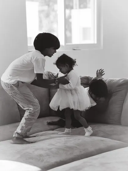 Family life is beautifully chaotic. This candid shot captures the playful energy of siblings interacting at home, showcasing the honest, unposed style of my black and white family photography.