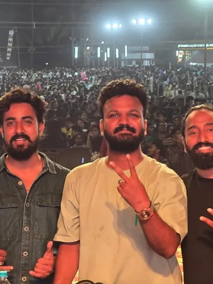 The whole team posing for a photo in front of a massive festival crowd.