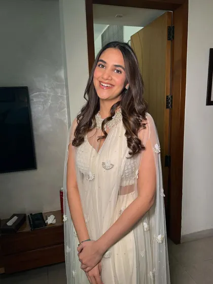A beautiful, happy client in a stunning white cape-style outfit. I gave her a soft, dewy makeup look with gentle waves in her hair.
