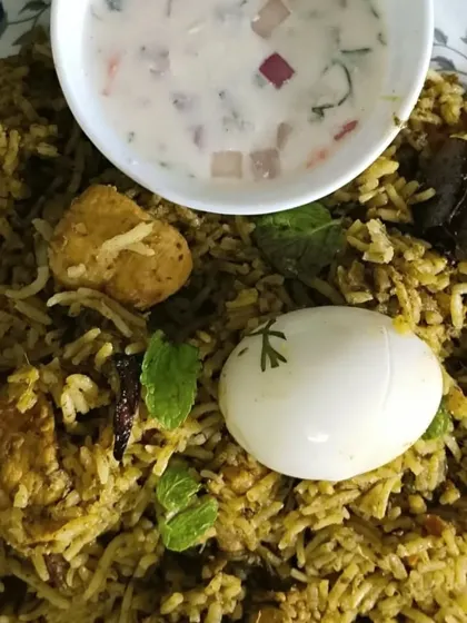 My Gongura Chicken Biryani is a tangy and spicy delight. The unique flavor of gongura (sorrel leaves) is infused into the tender chicken and rice, served here with a cooling raita.