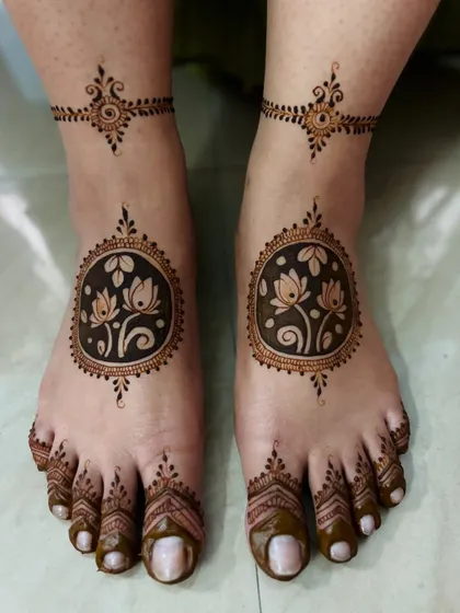 Ananya's wedding feet mehendi, featuring a unique design with lotus flowers inside a circular frame.