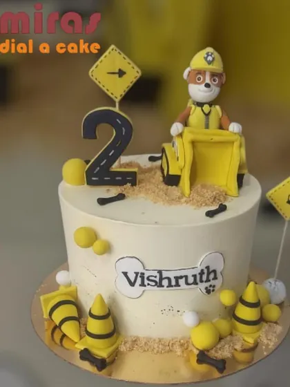 Rubble on the double! This Paw Patrol construction cake features Rubble in his digger, surrounded by cones and bones. It's a fun and playful design for a second birthday celebration.