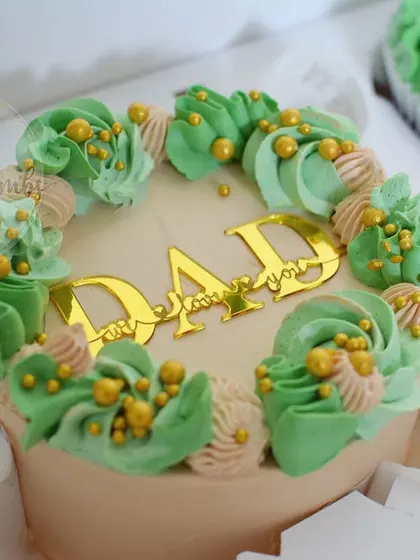 A close-up of the Father's Day bento cake. You can see the detail in the piping work and the gold acrylic "I love you DAD" topper.