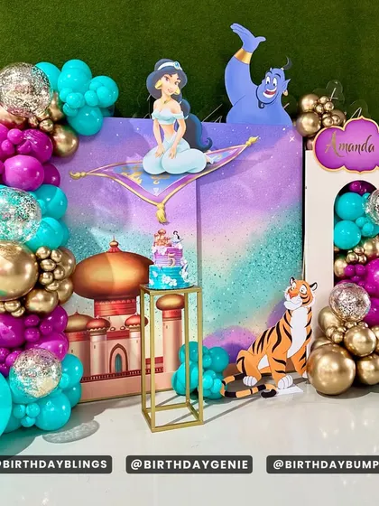 This angle of the Aladdin setup highlights the glitter-filled balloons and the golden plinth for the cake.