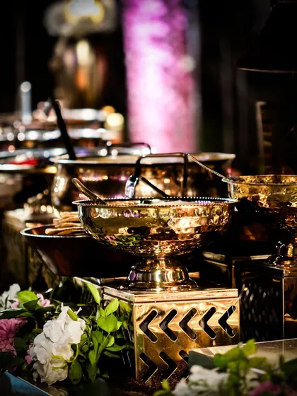 An elegant buffet setup using ornate brass serving dishes. This traditional serveware adds a touch of royalty and authenticity to an Indian food spread, enhancing the overall cultural experience for guests.