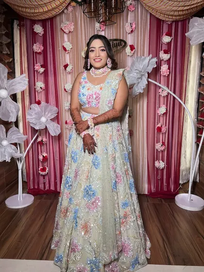 A full-length shot of the bride against a floral backdrop, looking absolutely joyful.