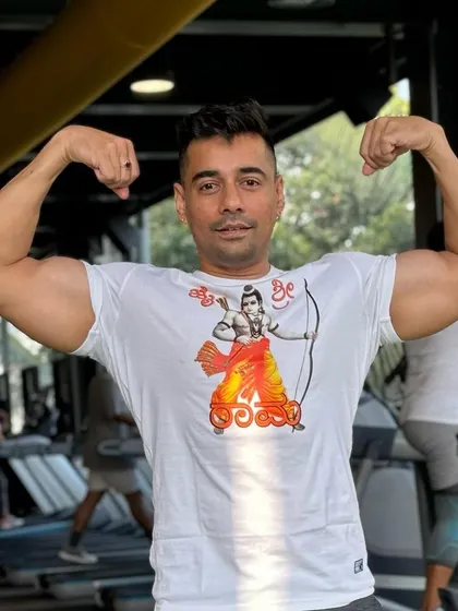 A member shows off his bicep gains, a testament to the hard work and dedication he puts in with the guidance of our expert trainers.