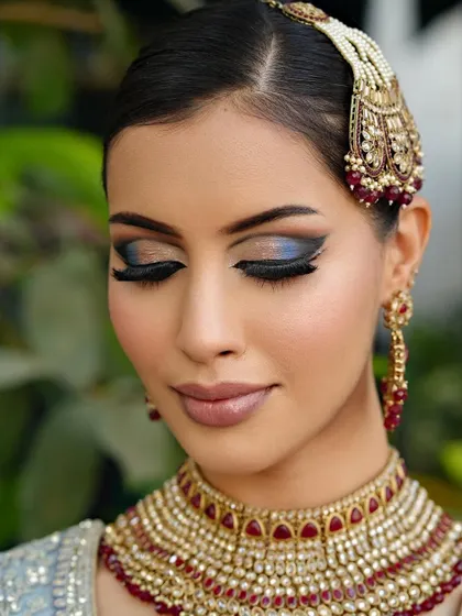 A close-up of the eye makeup, showing the beautiful blend of blue shimmer on the lid, framed by the dark, dramatic liner.
